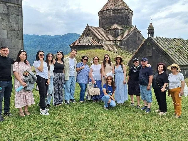 Group of tourists posing for a photo in front of Haghpat Monastery.